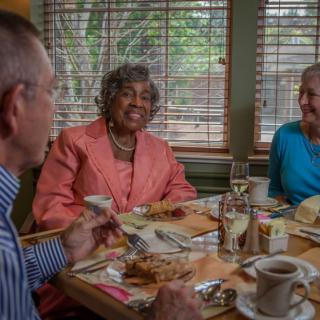 A group of seniors enjoying a meal together in a cozy restaurant setting.