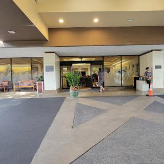 View of the entrance to a building, featuring a lobby area and pedestrians.