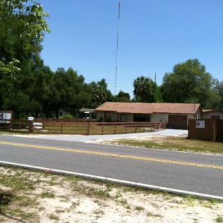 A suburban house with a wooden fence along a sunny street.