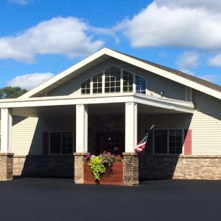 A building with a prominent entrance and an American flag flying outside on a clear day.