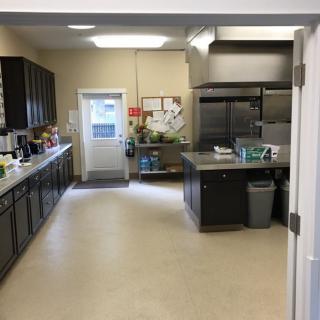 A spacious commercial kitchen with cabinets, countertops, and various appliances.