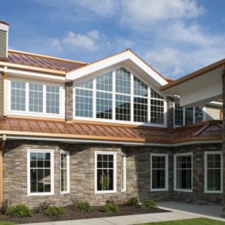 A modern residential house with large windows and a brick facade.