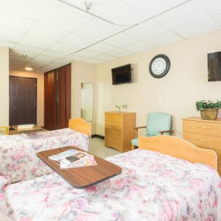 A well-lit hospital room featuring two beds, designed for patient comfort and care.