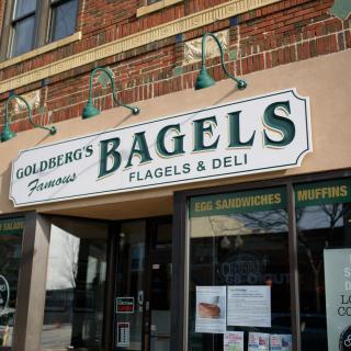 Storefront of a bagel and deli shop with prominent signage.