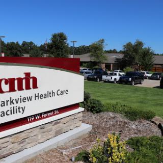 A sign for Parkview Health Care Facility with a clear blue sky in the background.