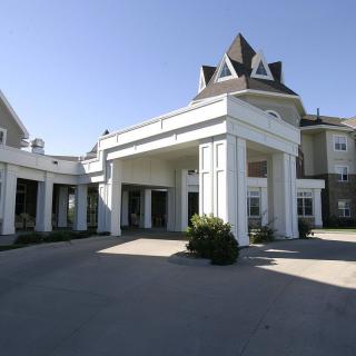A grand entrance to a residential building with prominent columns.