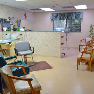 An empty waiting room with rows of chairs and a reception desk.