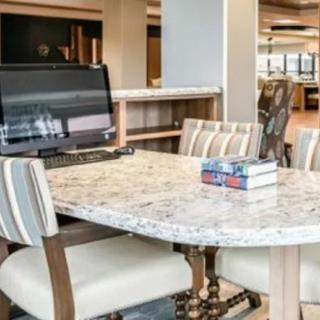 A modern office workspace featuring a marble table, computer, and books.