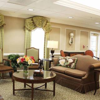 A well-furnished living room with a sofa, chairs, and decorative elements.