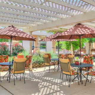 A beautiful outdoor patio area with comfortable seating and shaded umbrellas, perfect for enjoying a sunny day.