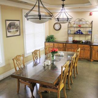 A beautifully arranged dining room featuring a large wooden table, elegant chairs, and modern lighting.