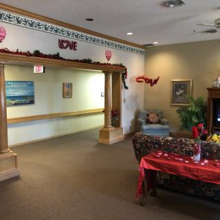 A cozy living room with seasonal decorations, featuring a table set for an event and a comfortable seating area.