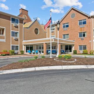 The exterior view of a hotel entrance with flags displayed.