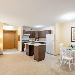 A modern apartment interior with an open-layout kitchen and dining area.