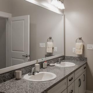 A modern bathroom with a double sink and granite countertops.