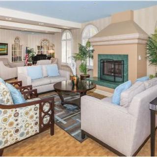 A cozy and elegantly decorated living room featuring comfortable seating and a fireplace.
