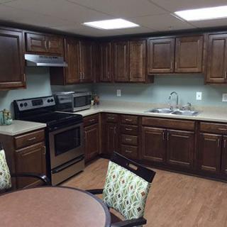 A kitchen with dark wooden cabinets and modern appliances.