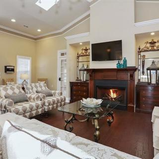 A cozy living room with a fireplace and television, featuring comfortable seating and elegant decor.