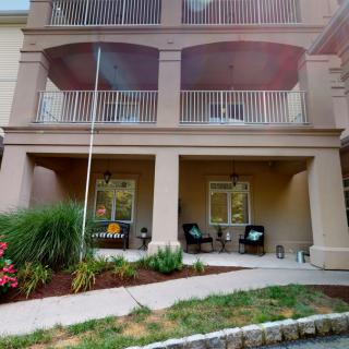 An apartment building with balconies and a garden patio area.