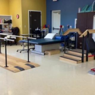 A physical therapy room equipped with parallel bars and exercise stations designed for rehabilitation purposes.