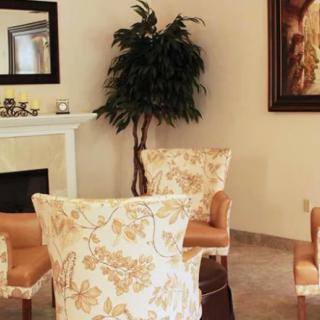A cozy living room with elegant chairs, a fireplace, and decorative elements.