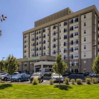 A multi-story medical facility with a parking lot and landscaped grounds.