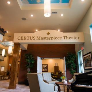 Interior view of a theater lobby with comfortable seating and decorative elements.