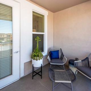 A cozy patio space with modern outdoor seating and a decorative plant.
