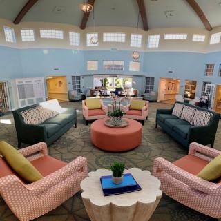 A spacious and well-decorated living room with comfortable seating arranged around coffee tables, creating a cozy and inviting atmosphere.