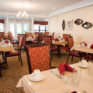 An elegantly set dining room with neatly arranged tables and chairs, ready for guests.