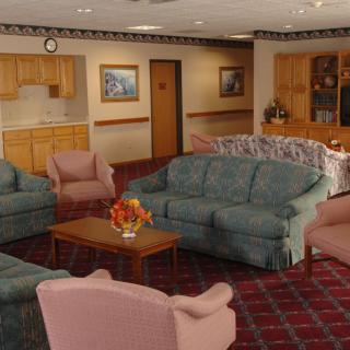 A cozy living room with comfortable sofas and armchairs arranged around a wooden coffee table.
