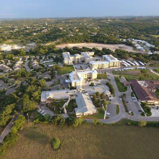 Aerial view of a residential area showcasing buildings surrounded by lush greenery.