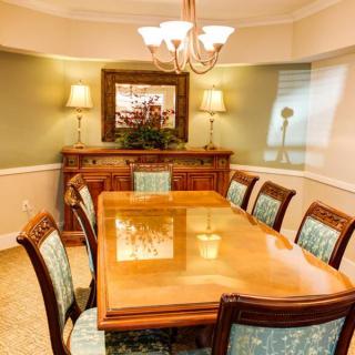 Elegant dining room with a wooden table and upholstered chairs.