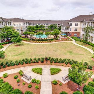 A view of an apartment complex courtyard featuring well-maintained landscaping and pathways.