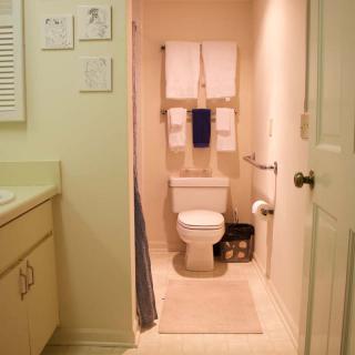 A neatly organized bathroom with a toilet, sink, and towels.