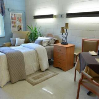 A well-decorated bedroom with a cozy bed, nightstand, and stylish furnishings.