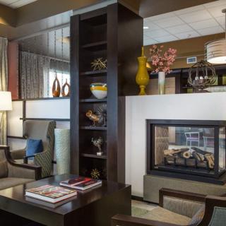 A cozy living room interior with a modern fireplace and stylish decor.