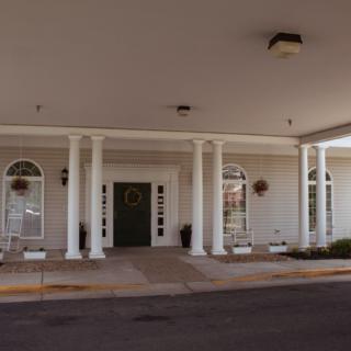 The entrance of a building featuring arched windows and decorative columns.