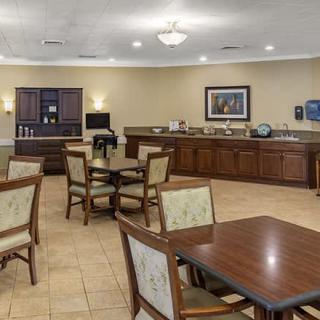 A cozy dining area with tables, chairs, and a coffee station.