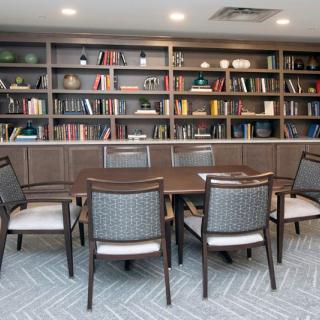 A meeting room with bookshelves lining the walls and a table surrounded by chairs.
