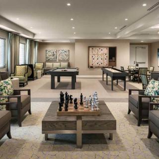 A stylish game room featuring a chess set, foosball table, and pool table with modern decor.
