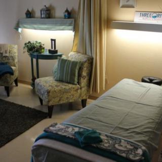 A tranquil spa room designed for relaxation, featuring a massage table and cozy seating.