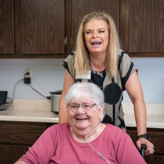 A joyful moment shared between a caregiver and a senior resident.