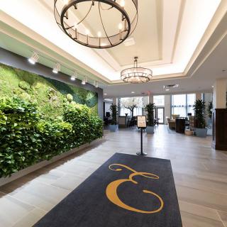 A modern lobby with lush greenery and elegant chandeliers.