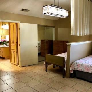 A spacious bedroom featuring a comfortable layout with wooden furniture and ample lighting.