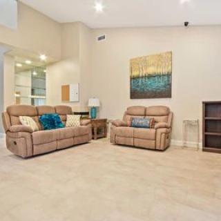 A cozy living room featuring beige sofas, a wall painting, and modern decor.