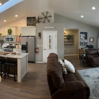 A modern open floor plan featuring a cozy living room and a well-equipped kitchen.