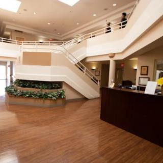 A modern lobby area with a reception desk and open staircase.