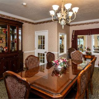 An elegantly designed dining room featuring a wooden table surrounded by ornate chairs and a stunning chandelier.