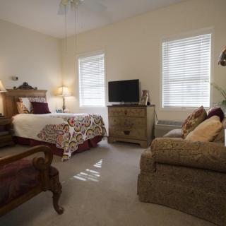 Cozy bedroom with a bed, sofa, and television.
